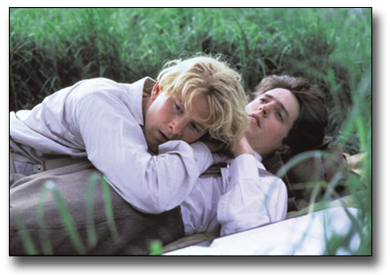 Scene from Maurice movie of two men lying in the grass on top of each other