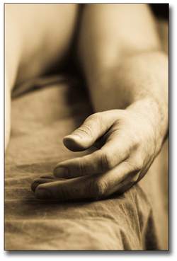 Male nude lying with a close up on the texture of his hand.